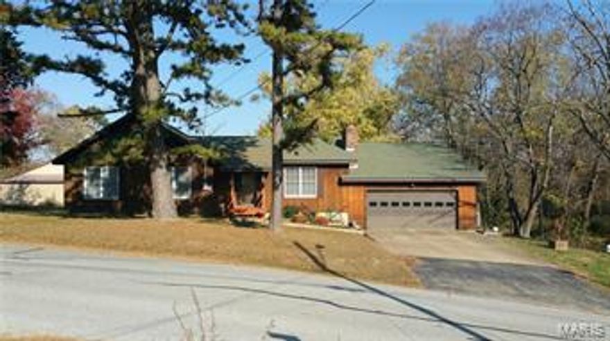 HUGE REDUCTION on this Rustic style home on a 3/4 ac m/l corner lot in town!  This spacious home features an open living-dining-kitchen, & vaulted ceiling.  3 BRs/2BA. Lovely sun-room w/door to deck, lockable gun safe room, & lg walk-in closet.  Kitchen has plenty of cabinets & work space w/breakfast bar open to sun room. Wood-burning Fireplace in living room. Master BR offers huge tiled master bath, TWO walk-in closets & sliding glass doors to deck!  Main floor laundry.  Partial, walk-out basement has a summer kitchen, & a finished room that could be an extra BR, game, hobby, exercise or storage room, plus an adl storage area big enough for your riding mower!  You won't run out of storage in this house!  2-tiered deck overlooks a beautiful park-like yard w/ mature trees & garden area.  Attached garage 21x21 w/opener, adl storage & easy access to fireplace clean out.  Detached shop 30x48 has conc. floor, elec., 1/2 bath, RV hook-up, attached 1-car garage 36x15, & 1-car carport 29x12. Additional Rooms: Sun Room