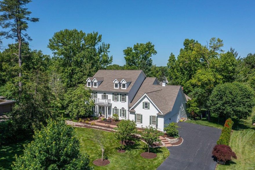 Spectacular 1.5-sty Southern Colonial with over 6000 sf of living space enhanced by soaring ceilings, detailed trim work, palladian windows & oak hardwoods that extend throughout the main living area. 2-Sty foyer highlighted by dramatic sweeping staircase leads to formal living & dining rooms & stunning great room with marble fireplace, wet bar & 2-sty windows that overlook parklike backyard. Spacious open kitchen with granite countertops, white Shaker cabinetry, premium appliances & butler's pantry adjoins breakfast room with planning center & vaulted hearth room with floor-to-ceiling stone fireplace. Master bedroom suite with beautifully appointed bath with jetted tub offers a relaxing retreat. Front & rear staircases access 3 additional bedrooms, 2 with ensuite baths, bonus room & hall full bath. Lower Level includes recreation room, game room with wet bar, family room with 3rd fireplace & guest suite. Situated on a .9-ac lot with deck, patio & pool surrounded by landscaped gardens.