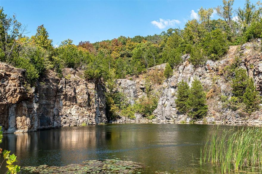 An UNBELIEVABLE 49.5 acre property awaits the lucky buyer who has been searching for a little piece of tranquil living tucked amongst the trees, just minutes from town! A gorgeous lake filled w/fish, sits between high bluffs w/woods to explore & enjoy, as does the abundant wildlife! High on the hill, the quaint A-frame home is found w/large windows to allow views of the peaceful, wooded setting! A spacious & open living space includes the large living room w/cozy wood stove & high wood beams that opens to the dining area w/sliders that exit to the wrap-around deck, while the kitchen offers good workspace! Two bedrooms, 3 full baths & an open loft area gives everyone room to spread out plus the walk-out basement offers more usable space. Some TLC needed but so many possibilities! A detached 3 car garage & shed gives added value. Previously a working quarry (1960's), lots of options exist for a business or simply a wonderful place to call Home. Make it YOURS! *Sold As Is* *2 Tax IDs*