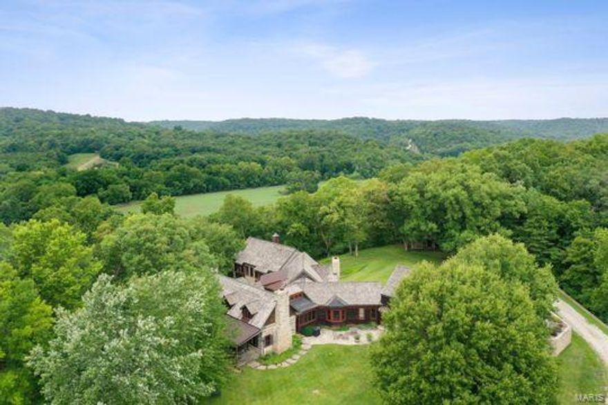 Situated on approx. 39 acres, this private retreat with 360-degree views, will take your breath away. This stunning estate is one of a kind with a list of special features that are sure to impress. At the core, a log cabin was reconstructed on the property in 1993 from Troy MO dating back to the 1880's. In 2009, a large addition was added on to the rear of the log cabin with all the custom features one could only hope for. The house totals over 5,500 sq ft. 4 car garage. 5 fireplaces.  The log cabin is home to the formal living room, dining room and 2 bedrooms upstairs with full bath. At the center of the home is the vaulted Great room with a large stone fireplace that opens to an amazing kitchen that won the 2011 National Kitchen and Bath Award. Custom cabinets, counters, flooring, and appliances with a breakfast nook and built in bench. A private office has built in bookcases. Spacious master suite on the first floor.  Private apartment above garage with bedroom, bath, family room. Suitable for Bed/Brk Additional Rooms: Sun Room