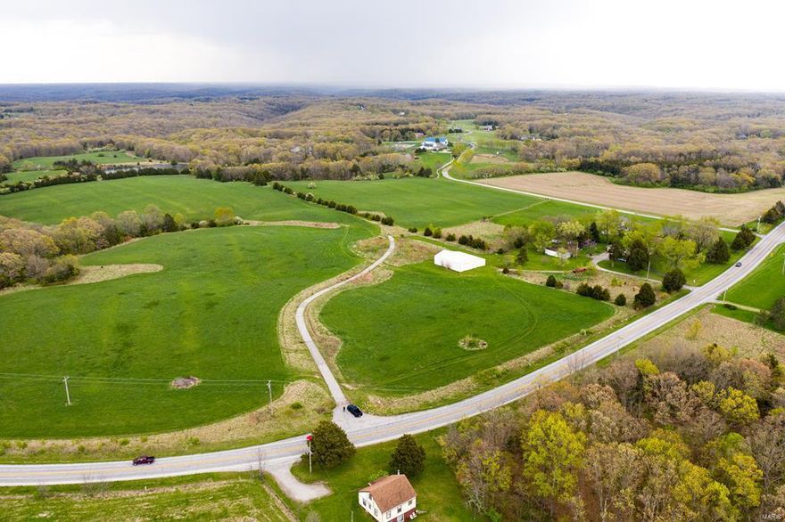 Great opportunity to invest in your future estate or a development ready property. These 87 acres have already been prepped for development with a MODOT approved apron to Highway 47 that can support multiple households. County water has also been pulled 700' onto the property, capable of serving multiple homes. There is a long, open ridge covering the front 2/3 with 55 acres of hay field. Then you will walk through an old cedar fence row to find a crystal clear, 2.5 acre lake. Beyond that, a perfect building site overlooking the lake and surrounded by mature trees. When you take a stroll through woods you'll see massive oaks and hickories along a wet weather stream. There is 60x60 machine shed and 1100 square foot ranch home as well. Come see this great opportunity to invest in 87 acres, on black top, ready to divide and develop, or build your private estate.