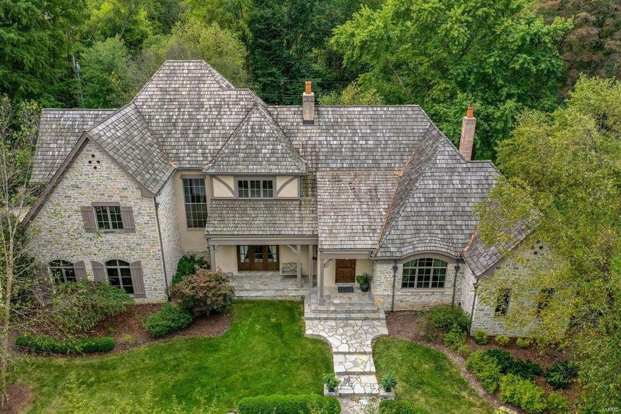 Situated on a beautiful 1.29 Acre Lot, this Extraordinary French Estate home redefines luxury living. Impressive foyer leads to elegant dining room, handsome study w/ maple bookshelves & stunning great room w/ rustic beamed ceilings, cast stone fireplace, wine cellar & French doors that open to expansive veranda. Designer kitchen with 42” custom cabinetry, granite countertops & commercial grade appliances adjoins breakfast room & hearth room highlighted by Tuscan styled fireplace. Coffered primary bedroom suite, luxury marble bath w/ freestanding tub & shower spa offers an appealing retreat. A second ensuite bedroom completes the main floor living space. The 2nd floor extends the living quarters w/ 3 bedrooms, Jack & Jill bathroom &. generously sized bonus room. Lower Level includes recreation room w/ gathering bar, fitness studio, 1/2 bath, sleeping area, office & full bath. Exterior features 4 car garage, resort style pool & hot tub surrounded by landscaped gardens & pergola