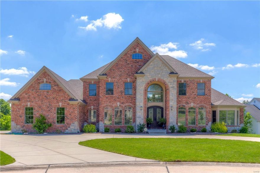 Beautifully-designed 1.5-sty Estate home in premier gated neighborhood! 2-Sty arched porch entrance with extraordinary wrought iron double doors leads to grand porcelain foyer highlighted by dramatic curved staircase, elegant living and dining rooms & spectacular great room with barrel-vaulted entryway, marble fireplace, wet bar & 2-sty wall of windows. Spacious open kitchen with granite countertops, 42” cabinetry, professional quality appliances, 9’ center island & butler’s pantry adjoins light-filled breakfast room with atrium door to deck & vaulted hearth room with floor-to-ceiling stone fireplace. Coffered master bedroom suite with bay window, 2 walk-in closets & lavish bath offers an appealing retreat. Front & rear staircases access 3 generous-sized bedroom suites plus bonus room. Expansive walk-out Lower Level includes huge recreation room, game room & office. Situated at the end of the cul-de-sac on .76 ac grounds with deck, covered patio, circular drive & 3-car garage.