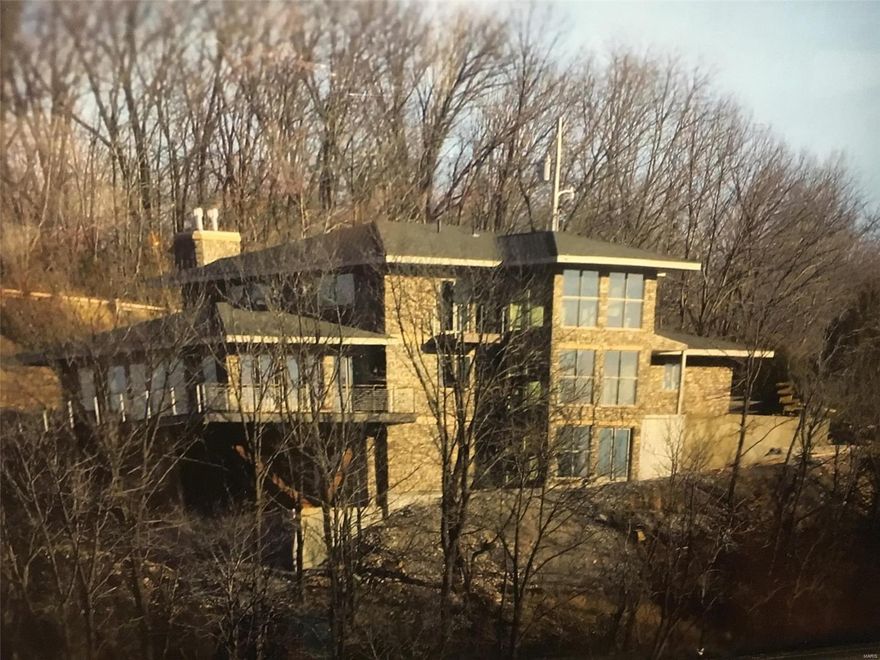 Stunning Views! Architecturally a Masterpiece! Perched on Hannibal's nationally recognized landmark, Lover's Leap. One acre lot with incredible views of the Mississippi River. Inspired by Alfred Hitchcock's "North By Northwest". Built in 2015 with three levels finished to perfection. Entry foyer features 3 stories of glass, custom designed steel rails, reclaimed pine stairs. Living room offers 180 degree views, 14' vaulted ceiling, heated Brazilian cherry floors. Gourmet kitchen is a must see-two walls of custom wood cabinetry, granite countertops, gas & induction 5 burner cook top, double convection oven, 6' side by side fridge/freezer, walk-in pantry, 2 dishwashers. Kitchen flows to dining area.Custom dining room table seats 12. Main floor Master bedroom suite opens to a 3 season room with a gas log fireplace. Upper and lower levels provide 4 suites and sitting rooms featuring full wall kitchenettes. 4 full baths, 1 half, 2 laundry areas. 5 Outdoor spaces. Home could be used as a B&B Suitable for Bed/Brk Some Accessible Features Additional Rooms: Sun Room