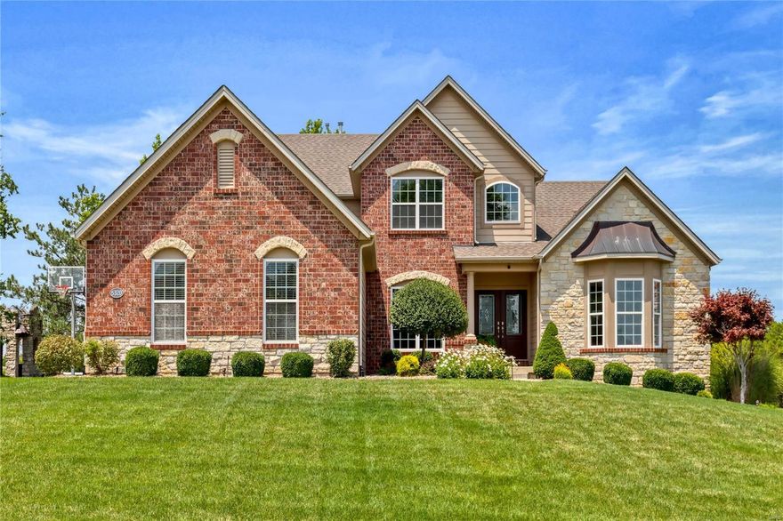 An impressive brick & stone elevation highlights the remarkable curb appeal of this outstanding 1.5 Sty from Fischer & Frichtel Custom Homes. Covered porch entrance with architectural column & leaded glass double doors leads to hardwood foyer, private study with wide bay window, formal dining room & stunning great room with stone fireplace flanked by built-in display cases & dramatic wall of windows. Designer kitchen features 42” glazed white cabinetry, granite countertops, stainless steel appliances & 9’ center island. The adjoining breakfast room with wine bar & light-filled gathering room provide a welcoming gathering place. Spacious primary bedroom suite offers an appealing retreat with customized walk-in closet, luxury bath & atrium door that opens to screened porch. The 2nd floor extends the living quarters with 2 additional ensuite bedrooms plus bonus room. Situated on a 1-acre cul-de-sac lot with tree-lined backyard & stamped concrete terrace surrounded by landscaped gardens.