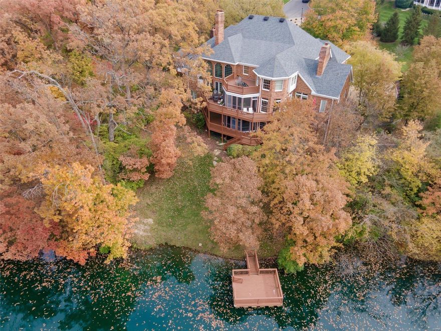 Stately Town and Country home on private 2.5+ acres! Nestled among trees with incredible views of private stocked lake complete with dock. Full Brick construction. Multi-zone geothermal heating and cooling! LOW UTILITIES! 2-story entry w/ turned staircase. Grand 2 story living room, fireplace, book shelves, wetbar, and balconies. Cozy wood paneled den/office with built-in bookcases and fireplace.  Master Bedroom suite includes private 3 seasons room! Do you like to entertain? This home is a dream for hosting small to large gatherings.  The Kitchen/Breakfast/Heathroom (which opens to deck and screened porch) is perfect for hosting family & friends!   2nd floor has 3 bedrooms & sitting room.   Lower level is perfect for in-law/guest suite and includes kitchen, 1+ bedroom, 3 baths, media room, game room, gym & family room with fireplace & private screened porch. Elevator service to all 3 levels.   Incredible Millwork & construction!  4car gar w/ EV charging. Plenty of extra parking space. Some Accessible Features