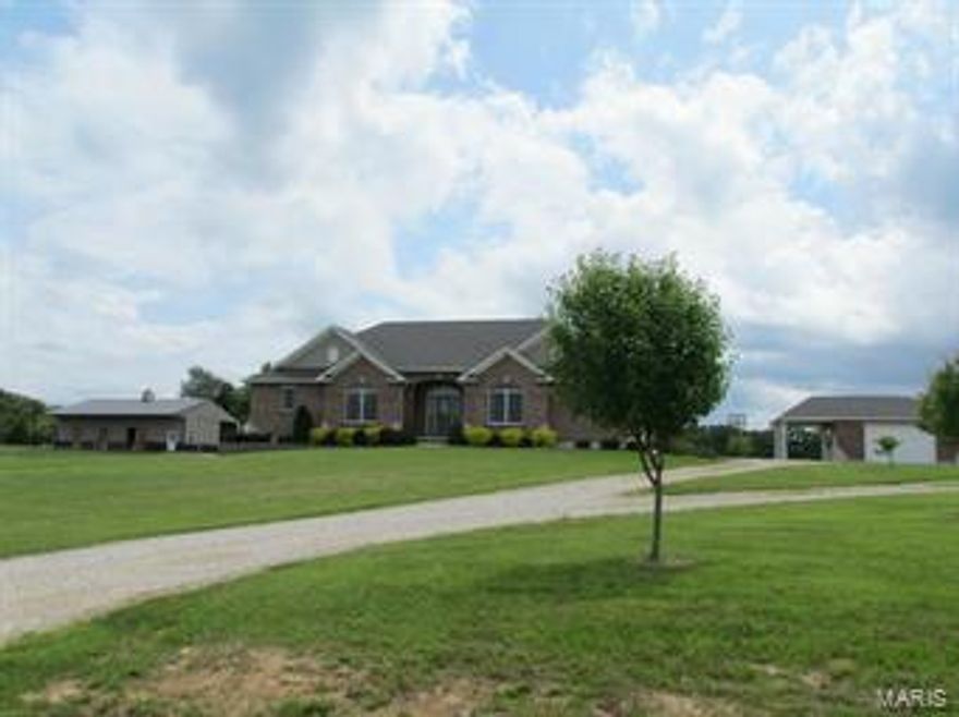 BEAUTIFUL CUSTOM BUILT, BRICK & STONE DESIGNED HOME W/KEYSTONE ARCHES ON 5 ACRES IN SPRING BLUFF! Spacious 4 BR 2-1/2 Bath w/9ft ceilings in the full, unfinished, w/o basement. BRAND NEW roof & gutters to be installed on the house & 28x28 matching detached 2-car garage w/12ft carport. Entry foyer to 12ft ceiling in the living room w/a soaring ventless gas fireplace flanked by over-sized windows. Open floor plan w/a large central kitchen that has a breakfast room & includes all stainless appliances. Formal dining room w/coffered 10 ft ceiling. All fabulous wood flooring & ceramic tile. All 4 BRs have large w/in closets. MBR suite has a 10ft tray ceiling, bamboo flooring, his & her w/in closets, & bath w/double vanity, whirlpool tub, & sep. shower. ML laundry. High efficiency propane 75 GA water heater & furnace w/heat pump. Plus 23x23 attached 2-car garage, 21x7 covered back porch, & a decorative 25x24.7 stamped back patio. Suitable for horses w/a NICE 52x36 pole barn w/3-12x12 stalls.