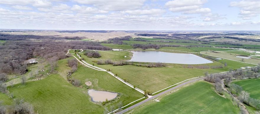 Beautiful 435 +/- acre cattle farm in scenic Pike County! Fronting Highway D, this farm has it all! Gated entrance with white vinyl fence lined driveway make this a showplace.  Great mix of woods and pasture-perfect for cattle, horses, hunting and more!  Excellent hunting-plentiful trophy deer and turkey.  30+/- acre lake with boathouse and dock.  White vinyl fencing and cross fencing, outbuilding, 2 ponds.  1 1/2 story partial brick home featuring 4BR/3.5BA, large kitchen, spacious living room with fireplace, formal dining room, huge recreation room with stone fireplace, attached 3 car garage, circle driveway, full basement, covered front and back porches, county water and septic.  There are countless gorgeous building sites on the farm. Stunning views everywhere you look!