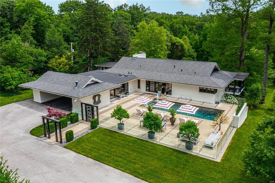 Esteemed architect William Bernoudy’s 1961 Symington house has been fully renovated into a contemporary masterpiece. Located on private 1.93-acre lot on premier STL street, guests enter thru a modern glass enclosure featuring a saltwater pool & beautiful landscape lighting. Inside boasts dark oak floors & vaulted ceilings. Living Room features stunning fireplace, floor-to-ceiling windows & wet bar with 2 wine fridges, & DW. Dining Room is papered in platinum leaf with dramatic chandelier & enclosed porch. Kitchen features SS appliances, 4 Gaggenau ovens (2 steam), range, 2 DWs, & dual fridges. Butler's pantry/main-floor laundry has fridge, DW, & plentiful storage. Master Bedroom suite has his/her baths & abundant closet space with dressing room. Pneumatic elevator & glass spiral stairs take you to fully-finished Lower Level with 2nd family room, fireplace, bedroom/ensuite bath, 2 bedrooms, 1 bath, 2nd laundry & storm shelter. Lush yard includes gardens & koi pond with waterfall.