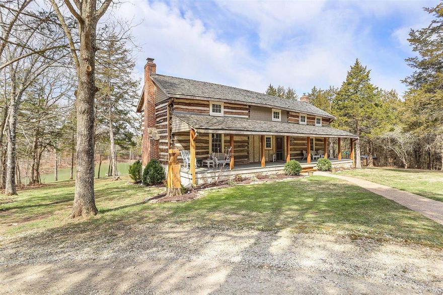 This 40-acre property has it all: a 3-acre lake w/dock, creek, dense woods, tillable bottom pasture & hunting food plot – and that's just the land! Privately nestled in the trees is an 1837 dogtrot cabin built w/oak logs up to 28in wide. The posts for the covered front porch & massive back deck were milled from cedars harvested here. The home was rebuilt at this site in 1993 w/all the modern updates! The living rm w/wide plank wood floors, open beam ceiling & brick fp w/stove insert opens into the kitchen/dining rm. Custom cabinetry curls around the kitchen, ending at a reworked vintage style cookstove. The massive kitchen island provides overflow seating from attached dining space. The main floor owner's suite features its own fp & private spa-like bath. Upstairs are two huge bedrooms & a possible 4th. The finished LL features a full kitchen & propane fp. The park-like setting also has 30x40 insulated garage/shop w/woodstove, garden shed & 16x20 log barn w/carport. Take a tour TODAY!