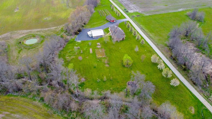 Heaven awaits on 152 Acres!! 133 tillable acres. This Stately Brick home (has 8.9 acres surveyed separately if wanted to divide after purchase) was built using all Redwood. The grand front entrance walks to on the open foyer and a 2 story hearth. The home features 5 bedrooms, the Primary Suite is located on the main floor. The open concept main level is perfect for entertaining. Off of the living room is an all seasons room so you can sit and enjoy the evening sunsets and take it easy. The lovely office makes working from home a little easier if work has to be done. Beyond the home there are 2 amazing additional buildings. One offers another kitchen, (where many a gallon of wine has been made with the established mini orchard/vineyard already) a bathroom, hot tub and 3 car garage. The other is set to look like a mini station and has 2 rooms and a kitchenette. This could be a retreat.