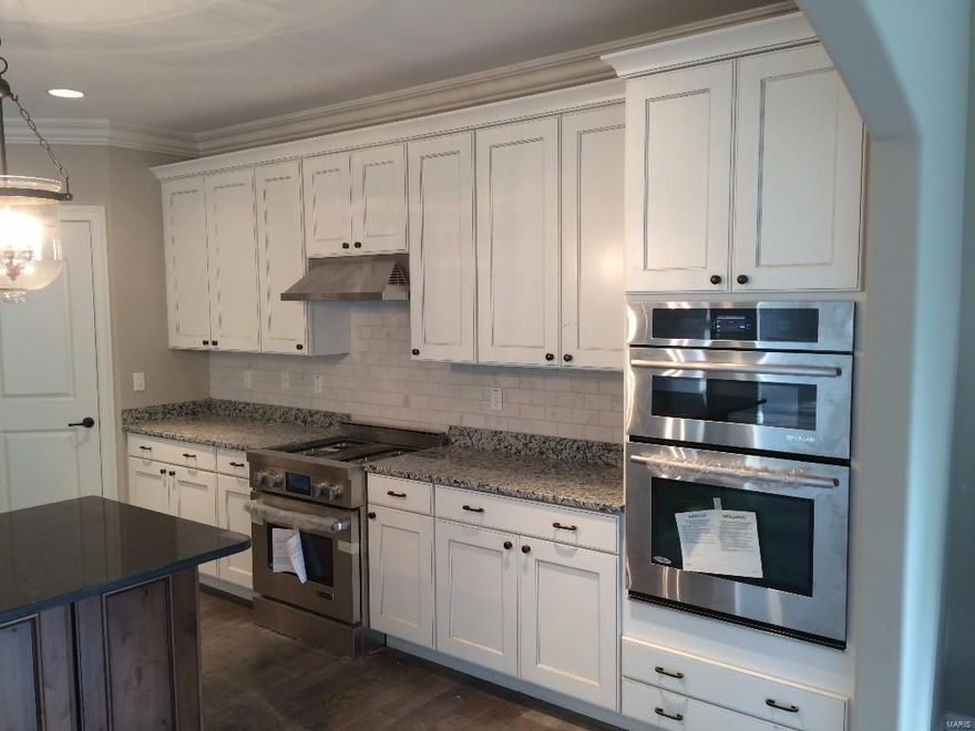 Spectacular 1.5 story new home almost complete by Prestige Custom Homes on a large walkout homesite in Belle Maison subdivision.  This 4 bedroom, 3.5 bath, home features a 3-car side entry garage, gourmet kitchen with custom cabinetry, crown molding, soft close drawers, granite countertops, Jenn-Air stainless steel appliances, built-in lockers, and impressive hearth room with vaulted ceiling and real stone fireplace.  Soaring 2-story great room offers a fireplace flanked by cabinets with built-in bookcases, hardwood floors throughout first floor, custom millwork,  study with double french doors, built in bookshelves, and vaulted ceiling.  Elegant master bath suite boasts coffered ceiling, separate walk-in closets, adult height vanities with granite tops, and vaulted ceiling in master bath.  Other amenities include a expansive 2nd floor bonus room, tall pour in basement, sculptured ceiling and wainscoat trim in dining room, outdoor room with fireplace.  Premium quality thoughout. Additional Rooms: Mud Room