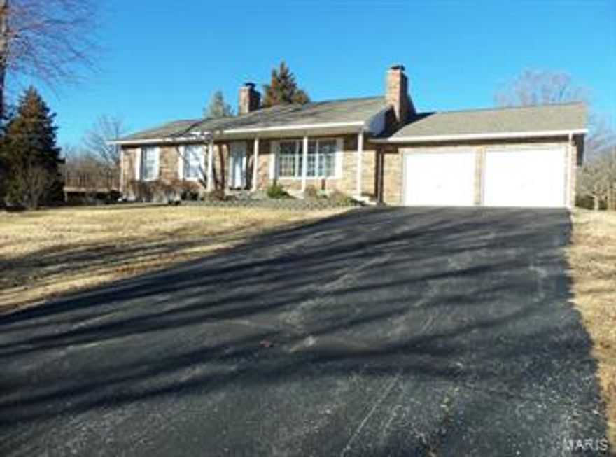 Turn off of County Road 4020 onto a lovely driveway to the property - 12.5 acres of cleared land and beautiful trees - 3 sides of property is fenced and the backside has  wonderful view of  large lake.  This home is a ranch style home featuring over 2600 square feet of living space, living room has a lovely brick fireplace and  very large kitchen with wood floors - off of the kitchen is a 10x24 screened porch. Nice deck to step out on from the master bedroom to enjoy your morning coffee.  Andersen Windows. Downstairs is a family room with another wood burning fireplace and a large patio area to relax. 3 outbuildings plus a 2 car attached garage. (Bedrooms in lower level do not have windows)
House is brick except for the west side is vinyl. This home has 2 bedrooms on main level but the plan was 3 bedrooms- could make the 3rd bedroom upstairs. Plus all the space and rooms in the lower level.
Property is only minutes from town and a pleasure to see.
