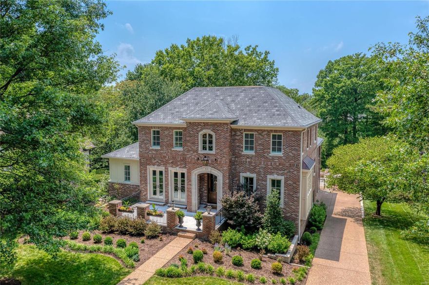 Situated on a .6-acre lot in Clayton’s desirable Country Club Place, this brick & stone 1.5 Sty features over 6000 sf of living space enhanced by oak hardwoods, 10’ ceilings & detailed trim work. Impressive entry foyer leads to formal living room with cast stone fireplace & 2 sets of French doors that open to terrace, elegant dining room & spectacular great room with wet bar & fireplace. Designer kitchen with marble countertops, commercial grade appliances, 9’ center island, butler’s pantry & beverage center adjoins light-filled breakfast room. Coffered primary bedroom suite with marble bath with laundry offers an appealing retreat. Hardwood floors continue to the 2nd level with 3 ensuite bedrooms, loft & 2nd laundry. Lower Level includes recreation room with wet bar, media room & full bath. French doors open to outdoor living area with deck with grilling station & full-height fireplace, pavilion with outdoor kitchen & 4th fireplace, patio with firepit & resort style pool with spa.