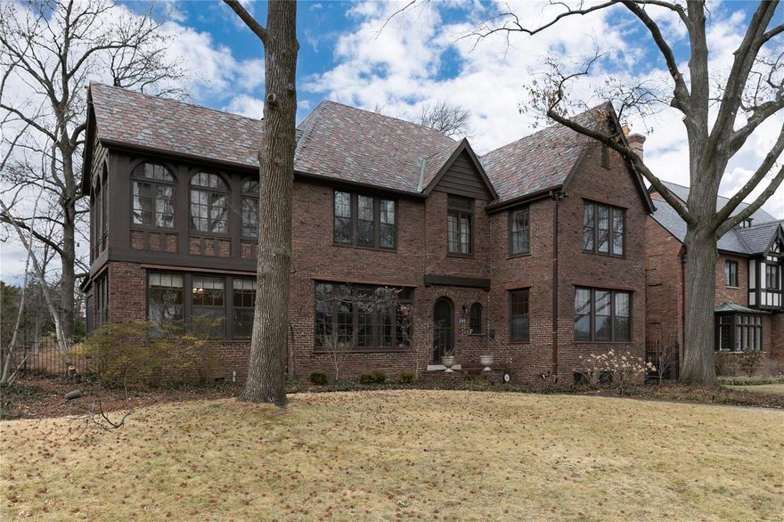 A Storybook Tudor that transcends time with the feel of a bygone era. Drunken brick exterior, slate tile roof, soaring ceilings, oversized windows, and period millwork are hallmarks of this 3,800SF home, a stone's throw from St. Louis' crown jewel, Forest Park. Heavy arched doors and wood floors define the house. An expansive living room with wood burning fireplace is the anchor for entertainment. The functional sunroom doubles as a main level billiard room walking out to a screened porch. Light filled dining room comfortably seats 8. Kitchen features ornate tile work, butcher block island, built in fridge, and cozy breakfast room. 2nd level includes 4 bedrooms with 3 full baths and a private den off the primary suite. Primary bedroom with vaulted ceilings is ensuite  with dual sinks and walk-in shower. Back stairwell leads to a bedroom suite, ideal for in-laws or au pair. 2 remaining bedrooms are adjoined by jack and jill bath, one with it's own sun/sitting room.