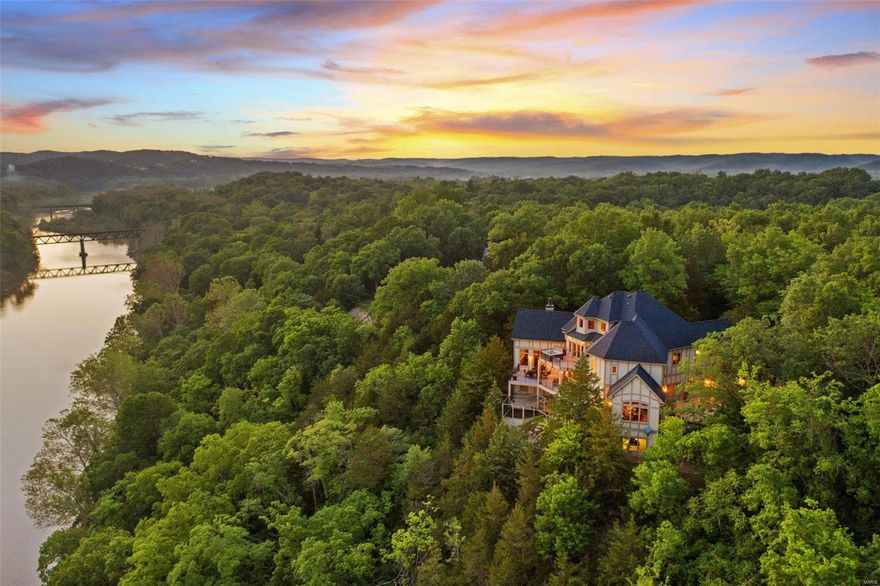 Luxury 4+ bedroom Estate Bluffside on Route 66 State Park with sweeping Meramec views. Stunning curb appeal with brick & limestone construction. Enter via 100+ year old STL Zoo Birdhouse doors. Interior wows with 4 levels, cable-driven elevator, 22 ft high great room, wood beams, custom FP, heated floors throughout, millwork, elegant formal Dining Room w/windows & stunning views, multi-deck access, hot tub, cedar sauna, and breathtaking Master ensuite w/huge walk-in closet. Opulent kitchen with Wolf oven/range, Sub Zero Fridge, Asko dw, custom hood, pot filler, built-in fridge, large island and hearth room. Front office with architectural ceiling & antique light fixture. 2nd level houses all 4 bedrooms. 4th floor sitting room with 1/2 bath (could easily become 5th BR). LL w/10 ft pour, & 12 ft cellar w/2300+ sq ft ready to finish. Generator & multiple HVAC zones controlled via BT. Enjoy privacy and peace out on the back deck all while taking in the magnificent sunsets!