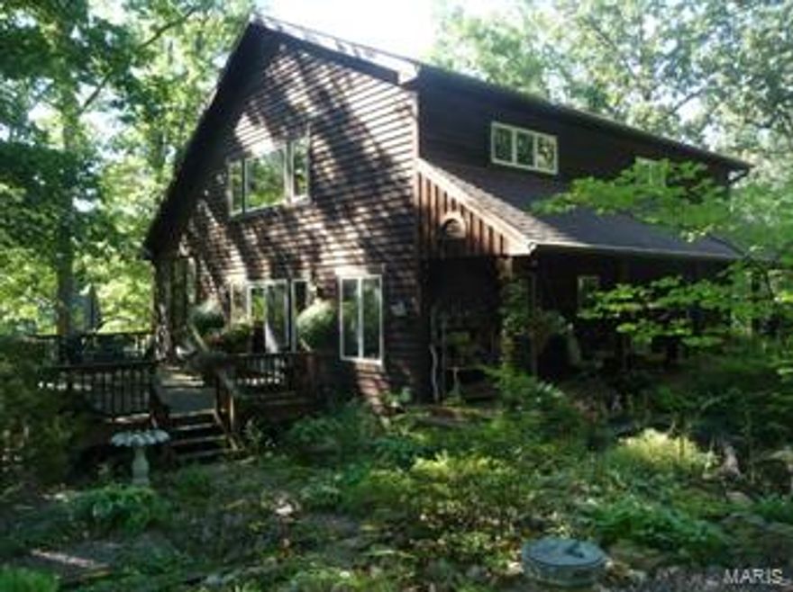 Beautiful quality built home in the woods near Mark Twain Lake.  Home and 5.7 Acres is just minutes from Spalding Beach and Boat Ramp and the Mark Twain Landing Resort.  Public hunting lands are within walking distance.  Quality features include 6 panel wood doors, Andersen windows, custom made maple railings to upstairs, and hickory cabinets.  Energy efficient features include 2x6 walls, foam insulated basement walls, super-insulated water heater, and a ground source heat pump system. Covered front porch, 16 ft x 21 ft wood deck, and 10 ft x 36 ft screened porch.   All wooded tract has stocked pond with deck.  Metal 36 ft x 36 ft building has 2 over head doors, electric, and concrete floor.  3 other outbuildings including one with dog pen. Additional 8.9 Acres of adjoining wooded land available for $35,900.00.
