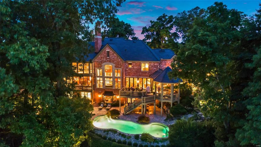 A private 10 acre oasis in a gated secure neighborhood with breathtaking views of the MO river. Sunsets are magical at this property. A spectacular European-style built home with handcrafted custom appointments throughout. Cherry wood staircase and balcony overlook the stone-walled great room. Living room/den leads to one of two primary bedroom suites. Main floor bedroom has a private office. the first floor also boasts a cook's kitchen, main floor laundry & formal dining room w/French doors that open to a limestone courtyard. Upstairs features primary suite #2 with hidden sitting room w/its own private porch, private covered rear deck, stack laundry hook-ups in bathroom, two walk-in closets and a gas fireplace. Two additional bedroom suites & bonus room over 3 car main level garage rounds out the 2nd floor. Walk-out LL includes a family rm, game rm, wet bar w/dishwasher, access to add'l 2 car garage & full bath that serves the in-ground pool. Newer roof and gutters (2015).