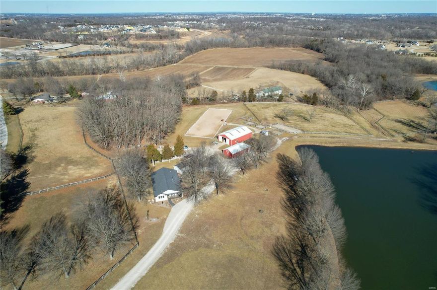 Stunning Equestrian property on 25+/- acres with a newer 1800+/-SF home of exceptional quality with cathedral ceilings in the living areas and 9ft ceilings in the bedrooms.  Covered stamped concrete patio overlooks a 3-acre, spring fed, stocked lake. Just off the back of the house sits an additional one room "bunk house" perfect for guests. A 24x51 concrete block building currently serves as storage for a tractor, up to 800 square bales, and has a separate workshop/storage space. The Horse barn measures 40x60, includes 4 oversized foaling stalls, 3 11x11 stalls, tack room, and a 3/4 bathroom. Multiple paddocks and turn-outs, 9 acres of fenced pasture in total, Outdoor all weather 20x60 meter riding arena and the list goes on.  Fantastic location, just minutes from shopping and amenities. (10 mins to Winghaven, 20 mins to Chesterfield Valley) Come see what you have been looking for! Duplicate listing of MLS #23007101
