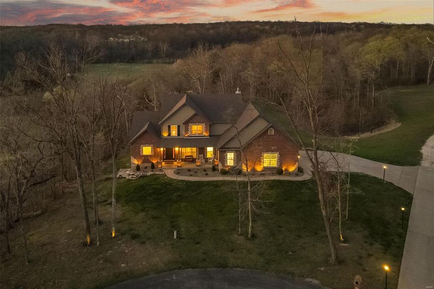 Surrounded by privacy, this remarkable home is a rare find. Located in a small enclave of just 3 luxury homes and tucked away in a cul-des-sac, those seeking a retreat have found their dream here.  This handsome home with brick and stone boasts 6 beds, 4.5 baths and lots of room to roam on 13 m/l acres with nice mix of timber and open ground bordering an all weather creek, plus HUGE 3+ car insulated garage with over 750 sq ft, 9' m/f ceilings, kitchen w/granite, custom cabs and walk in pantry. Warm hearth room with views of the land and FP.  M/F master suite, family room and beautiful floors and 2 baths on main.  Upstairs has a loft, 4 BIG beds and 2 full baths.  The LL hosts another bedroom and full bath with walkout to private patio.  The grounds showcase a 40X40 outbuilding with 12ft lean to's on both sides, poultry coupe, ATV trails, hunting stands, and ABSOLUTE privacy, peace and quiet.  This is a once in a blue moon offering so plan to visit soon.  We welcome you and thank you.