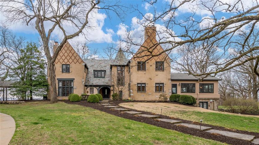 Experience the allure of a historic estate designed by Maritz & Young in 1928, just a half-hour drive from Clayton. The property spans 4 acres & boasts stunning views of the Mississippi River. This glamorous home features open living with high beamed ceilings, walls of windows, original light fixtures, terrazzo floors, hardware & massive limestone fireplaces. The chef's kitchen is equipped with granite counters, center island, double ovens, Wolf gas range, Sub-Zero refrigerators, chestnut floors & custom cabinetry. Enjoy views of the river from the sunroom/family room. The primary bedroom is gracious with a barrel-vaulted ceiling, fireplace, walk-in closet & bath. The lower level has a recreation room, ample storage & a 2 -car garage. There is a covered walkway to the detached, 6-car garage with a space above ready to be finished. A charming guest cottage with a living room, bedroom & kitchen adds to the estate's appeal. Take a dip in the huge pool and make this historic estate yours.