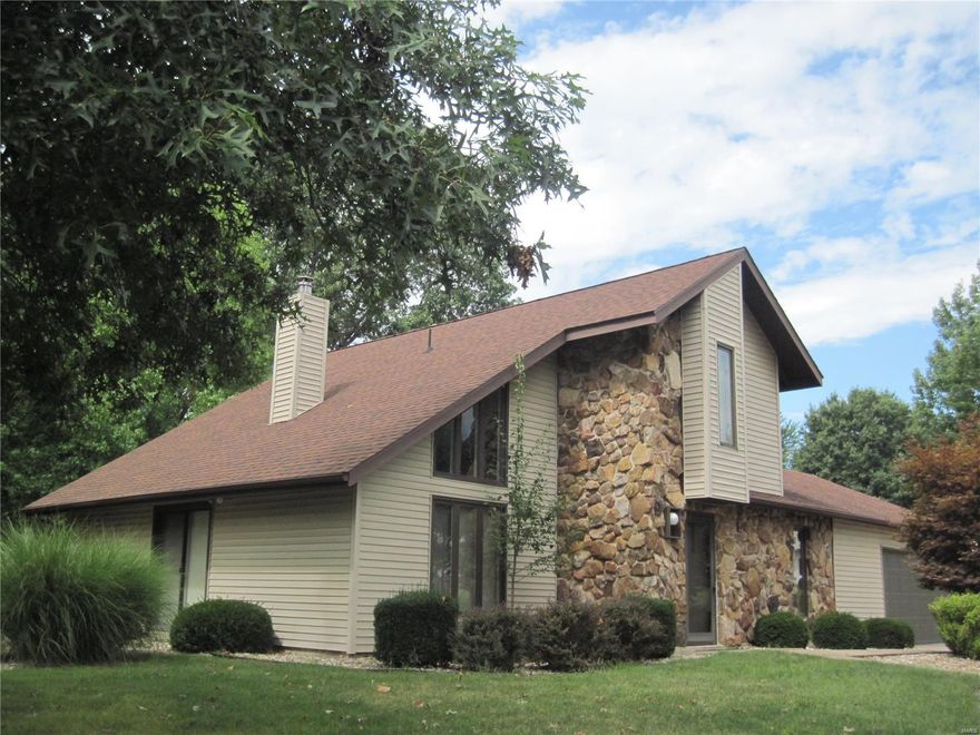 Welcome home!  The curb appeal of this lovely property invites you to the unique charm of this contemporary designed home.  Located on a large, corner lot in a desirable neighborhood, this home offers comfortable living with style. The impressive great room is accented with a vaulted wood ceiling, and a circular, stone wrapped wood burning stove.  Easy access to the patio and kitchen make entertaining enjoyable.  The main level offers the master bedroom suite with updated bath featuring a soaking tub and separate shower.  The kitchen has nice cabinets with updated hardware and newer countertops, and all kitchen appliances stay.  A powder room, laundry facility and 2 car garage complete the main level.  The upper level is accessed by a spiral staircase and offers a loft area used as a den or sleeping room, a second bedroom, and an updated bath with newer vanity, sink, tub and surround, stool, and lighting.  New 40 gallon gas water heater in 2021.  Hurry to make it your home!