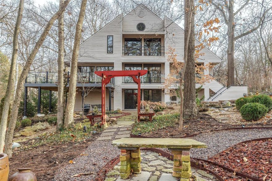 Elegance, style, location! This luxury home is centrally located with the atmosphere & grace of a vacation home. Situated on a full acre, the house was designed to bring the outdoors in with floor to ceiling windows and doors surrounding the main living areas and wraparound decks with glass railings to seamlessly connect inside & out. The interior is designed for entertaining and an executive lifestyle on split levels with hardwood floors, mosaic tile & stone features. Gourmet kitchen w/Opala granite, double oven, wine cooler, microwave drawers & ice maker. Dining/living areas on one level; guest room & spacious home office (or sleeping space) opening to a deck on the second level; step up to a master suite that is well-appointed w/his & her closets and spa bath. The lower living space features a bedroom, full bath & addtl space for entertaining. 3 car garage, circle drive & harmonious outdoor space with trails and meditation areas is the icing on the cake to this Asian influenced gem.