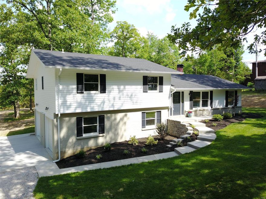 Nearly everything is BRAND NEW! Nestled back from the road among the trees, follow the NEW concrete walkway past the NEW landscaping, roof, vinyl siding & leaded glass front door to find beauty inside! NEW laminate floors & paint in the spacious front living room with a see-through fireplace & NEW lighting. NEW kitchen features white 42" soft-close cabinets, granite counters, NEW stainless steel appliances & gorgeous tile backsplash. The open dining room has a wall of windows overlooking the wooded yard & a cozy fireplace for warmth. Upstairs, the master suite has NEW carpet, 2 closets & a NEW private bathroom with lovely tiled shower. Three generous bedrooms with NEW carpet & a full bath with more stunning tile work complete the floor. Handy laundry/utility room off the family entrance & a sprawling unfinished storage area downstairs. Side-entry 2-car garage with a 10' extension. NEW deck overlooks 5 wooded acres perfect for horses. NEW HVAC. Francis Howell Schools. See it today!