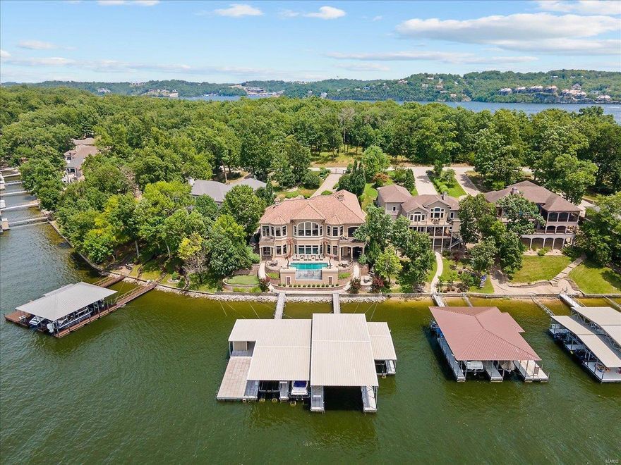 Luxurious Porto Cima Gated Lake Home with exquisite details, furnishings, patios, heated pool, putting green now embraces a totally renovated exterior of stucco & all the details. Grand front entrance of massive open spaces with 14 - 17 foot ceilings high grade features including spacious, beautifully detailed entertaining areas inside & out that will be sure to please you & your guest. Travertine floors, extensive millwork, custom tilework in baths, five suites, gourmet kitchen, lower level kitchen, a master en suite spa, 2 laundry rooms plus stack washer/dryer in Master. Upgraded & impressive infinity edge pool surrounded by stamped concrete and a wonderful outdoor fireplace, upstairs screened deck, bbq area and bar with minimal steps to the dock. Dock will more than accommodate your needs with four slips of various sizes (largest is 20 x 60), a bar/locker storage & large swim platform