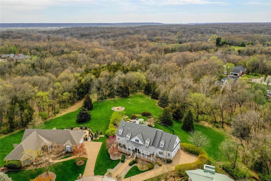 Spectacular 1.5-sty Southern Colonial on 2.3-acre grounds! Homearama showhouse with over 7400 sf of living space enhanced by wide plank pine flooring, millwork, skylights & arched entryways. 2-Sty foyer leads to elegant dining room & vaulted great room with fireplace, bookcases & wall of windows with private wooded views. Chef’s kitchen with granite countertops, commercial grade appliances & 7’ center island adjoins breakfast room with custom built-ins & hearth room with beamed cathedral ceiling & fireplace. Sumptuous master bedroom suite with marble bath & sitting room with cast stone fireplace provides an appealing retreat. Broad hardwood staircase accesses 3 additional bedrooms, 1 with ensuite bath & 2 with Jack n’ Jill bath, plus bonus room, workout room & 2nd laundry. Walk-out Lower Level features recreation room, gathering bar, wine cellar, guest suite & ½ bath. Outdoor entertaining area includes pool & spa surrounded by landscaped gardens, patio with grilling station & fire pit.