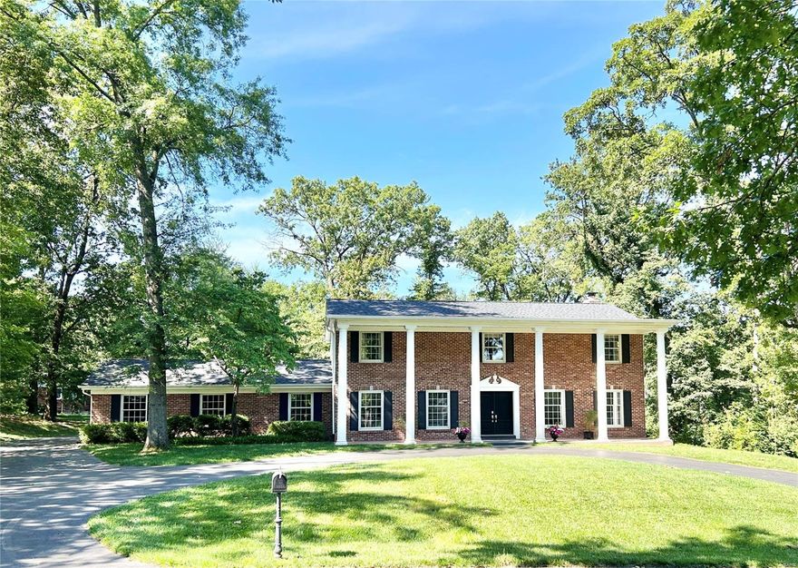 Showings begin Saturday, 6/15. Situated in a Ladue neighborhood of winding lanes, this freshly updated home is bright and neutral. New light hardwood floors extend through much of the main level beyond the gracious foyer with open turned stairs and wainscoting. Gathering room with fireplace and view of side woods adjacent to light and bright kitchen with white granite and stainless appliances. Main floor laundry room adjoins a separate private bonus room that could be used as an office. Primary suite upstairs with double vanity and three exposures. Outside, guests are welcomed by a circle drive leading to the large pillared front porch. A level yard with adjacent side woods area offers connection to nature. Premier Ladue Schools.