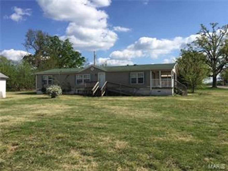 Fantastic Deal This Wont Last Long Bank says sell fast. Over 1540 sq ft double wide on concrete pads with concrete skirt on a corner lot in Richland Mo. This 3 bedroom 2 Bath Home has a full width covered deck a very open floor plan with a garage and another out building. Great lot very flat and clean in an excellent neighborhood. This is without a doubt the best buy for the money in the area. Whether you are a first time buyer or have a family or are retired you should really consider this home. Call today make arrangements to see this home today.