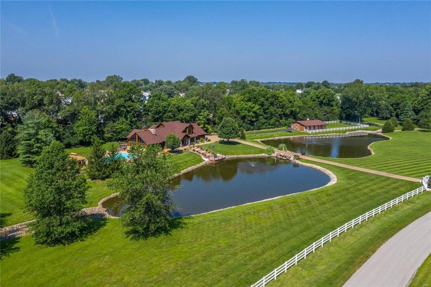 Exceptional gated rustic estate on parklike 7-acre grounds. This stone & cedar 1.5 Sty features soaring ceilings, oak hardwoods & expansive windows that offer continuous vista views throughout the home. Impressive entry foyer leads to private study, formal dining room with wine bar, spectacular great room with cathedral ceiling & stone see-through fireplace and paneled sunroom with fireplace. Designer kitchen with knotty alder cabinetry, granite countertops, KitchenAid appliances & horseshoe center island adjoins vaulted hearth room highlighted by floor-to-ceiling fireplace & adjacent gathering bar. Primary bedroom suite with beautifully appointed bath with shower spa provides an appealing retreat. The 2nd floor extends the living quarters w/3 additional bedrooms & hall full bath. Walk-out Lower Level includes recreation room, game room, family room, office, workout room & full bath. Premium cul-de-sac lot with deck, covered patio, pool & gazebo plus 3-stall barn & 2 stocked ponds. Additional Rooms: Mud Room, Sun Room