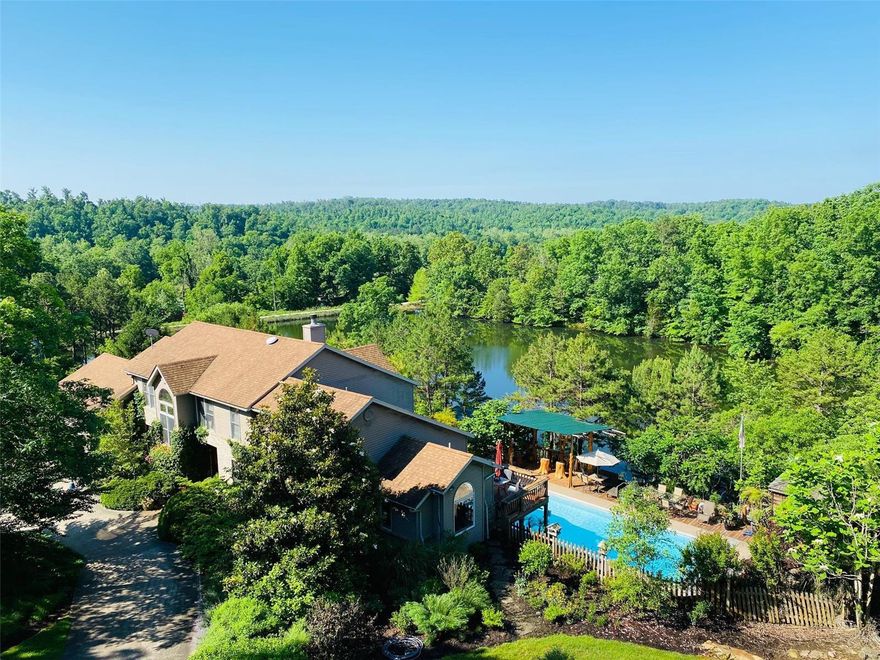 6-BR, 5-BA EXQUISITE HOME ON 92+ ACRES BORDERING NATIONAL FOREST
A beautiful recreational farm nestled in the Mark Twain National Forest in SE Missouri. This equestrian paradise has extensive riding trails into the National Forest and a clear spring fed 2.5 lake with a unique Adirondack style boat house, large boulder firepit overlooking the lake and a sand beach w/pine grove to relax by the water's edge.
This resort like property offers fishing, hunting & kayaking opportunities. The outdoor living is exceptional with a large Adirondack hand crafted pavilion overlooking the lake and inground pool, hot tub, large wooden deck areas, aggregate patio w/firepit, unique tiki bar, 35' waterfall and extensive landscaping with gardens galore! A master gardener w/over 20 yr's of professional landscape annual additions to expand the landscape aesthetics, a plant collectors dream. For the horse enthusiast, there's a 9-stall horse barn, tack room, corral & original hay barn w/20 acres pasture. Suitable for Bed/Brk