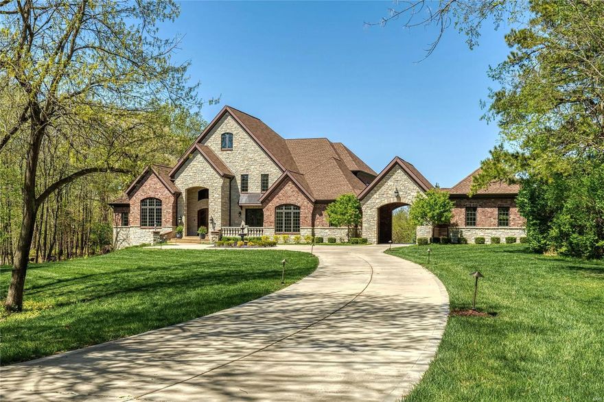 Superb craftsmanship & distinctive architectural elements define this magnificent 1.5-sty Estate home. Impressive marble foyer highlighted by dramatic sweeping staircase leads to library-paneled study, elegant dining room with French doors to terrace & stunning great room with wet bar, cast stone fireplace flanked by built-in bookcases, wine cellar & adjacent sun porch. Designer kitchen with custom cabinetry, granite countertops & commercial grade appliances adjoins breakfast room & vaulted hearth room with floor-to-ceiling stone fireplace. Spacious primary bedroom suite offers an appealing retreat with wide bow window, 2 walk-in closets & marble bath with shower spa. Front & rear staircases & elevator access 3 additional ensuite bedrooms & bonus room with 2nd laundry. Lower Level includes recreation room with gathering bar, family room with 3rd fireplace, game room, media room, 5th bedroom & full bath. Situated on a 1.7-ac lot with covered patio, grilling station & resort style pool. Additional Rooms: Wine Cellar