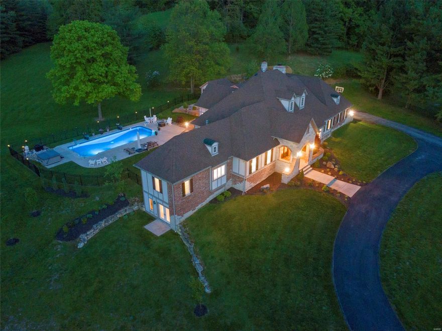 Wildwood, Rockwood Schools; Prestigious, custom built ranch ranch nestled on 9.8 level acres with stunning outdoor living area including 2 yr old pool, hottub, pool house & private bath. Ideal horse property!. The brick/stone elevation is accentuated by the arched double-door entry welcoming you to enjoy wide-plank, hand-scraped hdwd floors throughout the main floor. Features include tray ceilings, dramatic vaults, crown, built-ins & 2-panel 8ft doors. A grand center island is the highlight of the kitchen which includes top-of-the-line appliances, custom cabinetry, granite counters, tile backsplash & opens to the hearth rm w/floor-to-ceiling stone fireplace. Master suite boasts a deep coffered ceiling, master bath w/his-n-hers vanities, walk-in shower & custom walk-in closet and french doors leading to the private screed porch. Three BRs, one w/fireplace, & 2 full baths create the add’l bedrm wing. Finished walk-out lower level with bedrm, full bath, entertainment area & exercise rm.