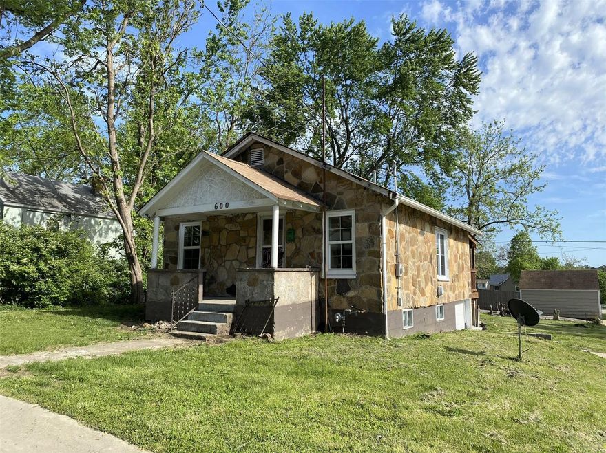 Neat stone home has 2 bedrooms 1.5 baths on full basement, all basement floor is ceramic tiled.  The home is situated on large corner lot just blocks from S&T.  Kitchen has Oak cabinetry, stylish backsplash, pretty solid surface countertops, tile floor, a door off to back deck, 8x14 m/l, and is open to dining, living room.  Nice open living room and rest of the main level have wood-look laminate flooring.  Vinyl windows, light fixtures, heating/cooling, water heater, roof, and guttering are less than 3years old.  8x10 m/l metal storage shed.  There is a garage door that tucks under in the basement, however, the basement is all open and may be better used as a recreation area.