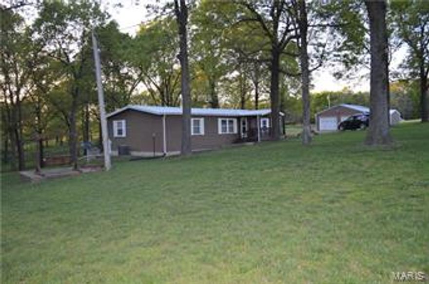 Darling 3 bedroom 2 bath mobile home on foundation!  Well maintained and move in ready! All electric, metal roof, double pane windows and lovely yard with that country feeling but not to far from town. Come and enjoy the covered porch, the meticulously care for yard and the 24X30 garage as well as the 18X24 workshop.