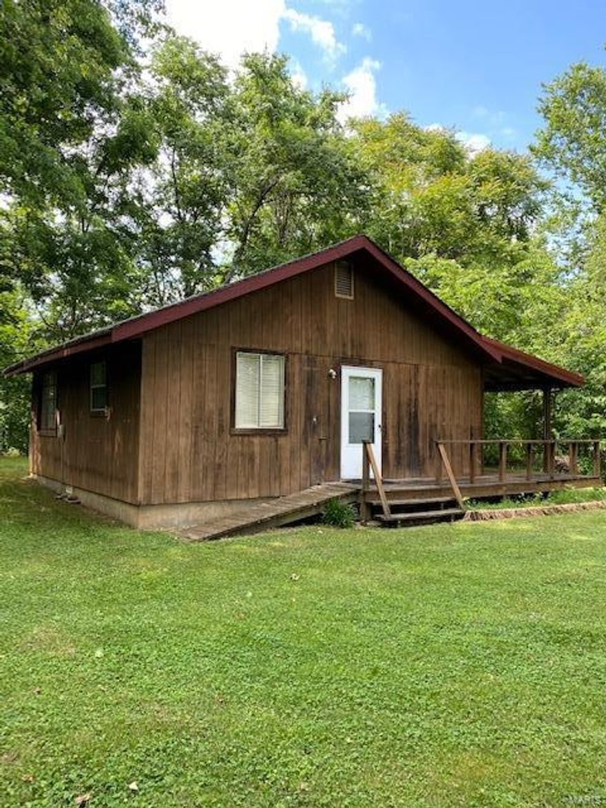 A cute little cabin sitting right on James Branch in Dillard, Missouri. A neat porch to sit on as you look across the country side and relax with the grandkids or just kick back for a nap. The rustling water of James Branch will most certainly put you to sleep each evening when you lay your head down. This cabin is an HGTV project with some repairs needed but when the day is over you can walk to the Huzzah River for a cool dip just under 200 yards away. This home is just a couple miles from the Dillard Mill State Park and nearby is thousands of acres of Mark Twain National Forest. This property has a small nearly new utility shed on the property to store all your tools and mower. There is Fiber Optic Internet available locally for your next Pandemic experience. Just work from home as you cool your feet in the James Branch. The town of Viburnum is just 6 miles away to get everything you need for your country home get a way. Priced at $49,995 makes this an easy purchase decision.
