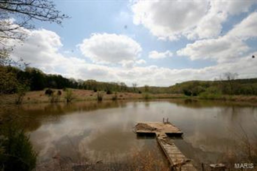 Own a piece of Missouri paradise.  158.6 acres of rolling hills, woods, fenced pasture and lake all near Boone Hollow golf course. This is a rare chance to purchase so much beauty Only 23 minutes from Hwy 40.    Land is currently being used for hunting, cattle, and recreation.     Call you agent today to schedule a private tour.   Must have truck or SUV to be able to drive through creek in photos to access gate.   Gate is locked and requires agent key to access.