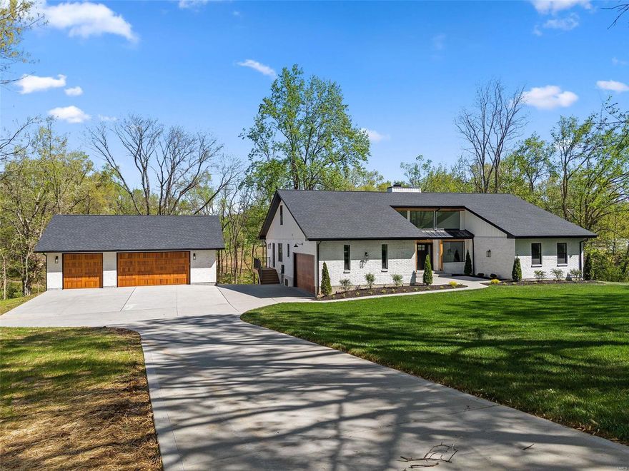 Elegant, stylish, unique, & nestled on 3.1 acres? You just don't see homes like this! This incredible modern styled home has been completely remodeled from top to bottom. One of a kind entryway w/recessed front & wall of windows for a plethora of natural light. Custom kitchen w/beige & sage cabinetry, quartz countertops, drink station, & matching doors to a hidden pantry boasting a "Costco Door". Expansive living room w/statement electric fireplace wall. Access to master bedroom from the living room with dual closets and a bathroom that will knock your socks off! Wet room w/custom tile, brushed brass fixtures, 3 shower heads, & a soaking tub! Main floor has an addtl bedroom, full bath, laundry, & powder room. 3rd private bedroom upstairs. Approx 920 addtl sqft finished in the basement w/family room, bedroom, & full bath. Large storage area with 1/2 bath & garage entry. Brand new 3 car detached garage & peaceful lake sitting toward the back of the property. You do not want to miss this!