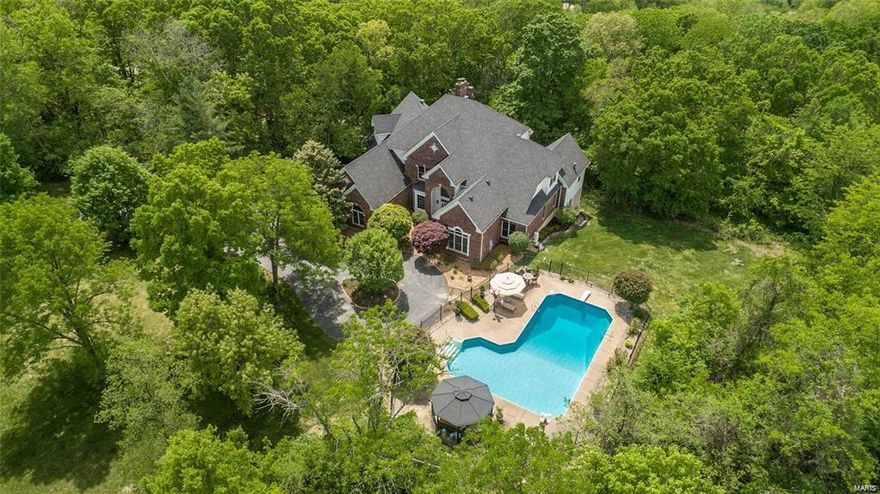 Simply exquisite, this 7200SF, 5BR/6ba, 1.5sty rests on 3acs of treed paradise with sparking salt water pool! Circle drive welcomes you to a gracious foyer w/curved stair, open balcony & detailed millwork. Open & airy 2sty GR has built-in bar, 25ft ceiling, f/p & soaring bowed wndws! DR w/tray ceiling, bay wndw & easy access to butler pantry & kitchen. Kitchen is packed with pizzazz; quartz, white cabs, glass backsplash, angled island, Jenn-Air appl. Comfortable vaulted hearth rm welcomes relaxation. Main floor master w/sitting rm, His & Her WICs, raised vanities, shower and pillared bathtub. 3 ensuites on 2nd flr, including a suite w/ sitting rm. Finished walk-out LL is headquarters for fun w/something for everyone; FR w/stone frplc, walk-in wet bar, fitness rm, theater, rec rm, 5th BR & full bath. Composite deck, HVAC -3 zones, 3 HWHs, 2 laundry rms & much more! Perfect combination of classic & modern combined with natures best! Minutes to Wildwood Town Center. ROCKWOOD SCHOOLS!