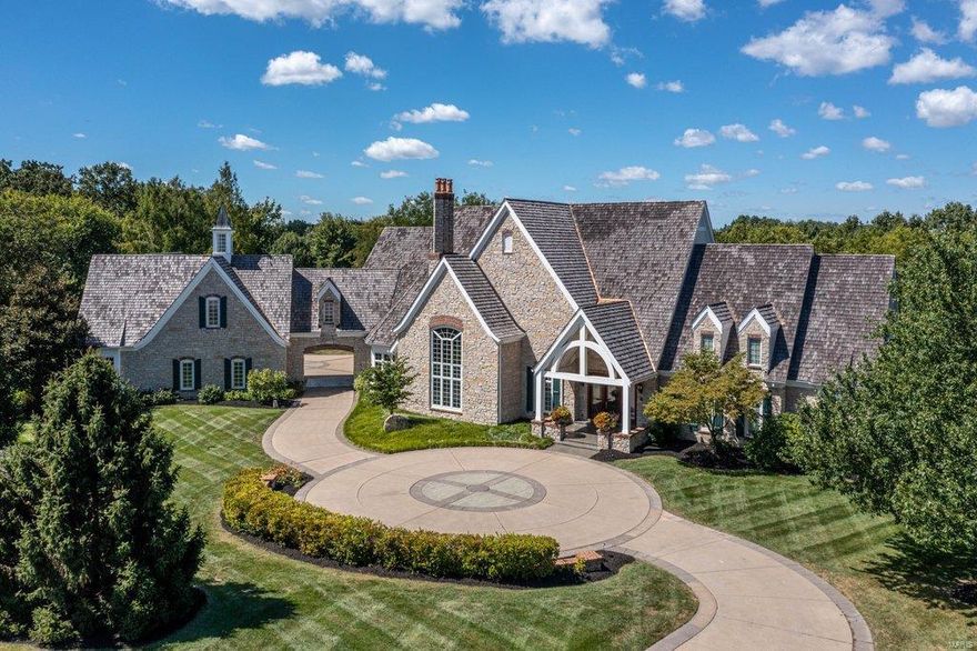 Exquisite European-inspired Estate home from award-winning Johnson Development. Grand marble entry foyer leads to private study with stone fireplace & custom built-ins, elegant dining room with atrium door to terrace & stunning great room with cathedral ceiling, floor-to-ceiling stone fireplace flanked by built-in bookcases & dramatic palladian window. Exceptionally large kitchen with 42” glazed cabinetry, granite countertops, commercial grade appliances & butler's pantry adjoins breakfast room with French doors that open to patio. Coffered master bedroom suite features wide bay window & beautifully appointed bath with jetted tub. 3 Additional ensuite bedrooms complete the main floor living quarters. Lower Level entertainment space includes recreation room, media room with granite fireplace, gathering bar, office, workout room & guest suite. Situated on parklike 3.6-acre grounds with hot tub & stamped concrete terrace surrounded by landscaped gardens plus porte-cochere & 6-car garage.