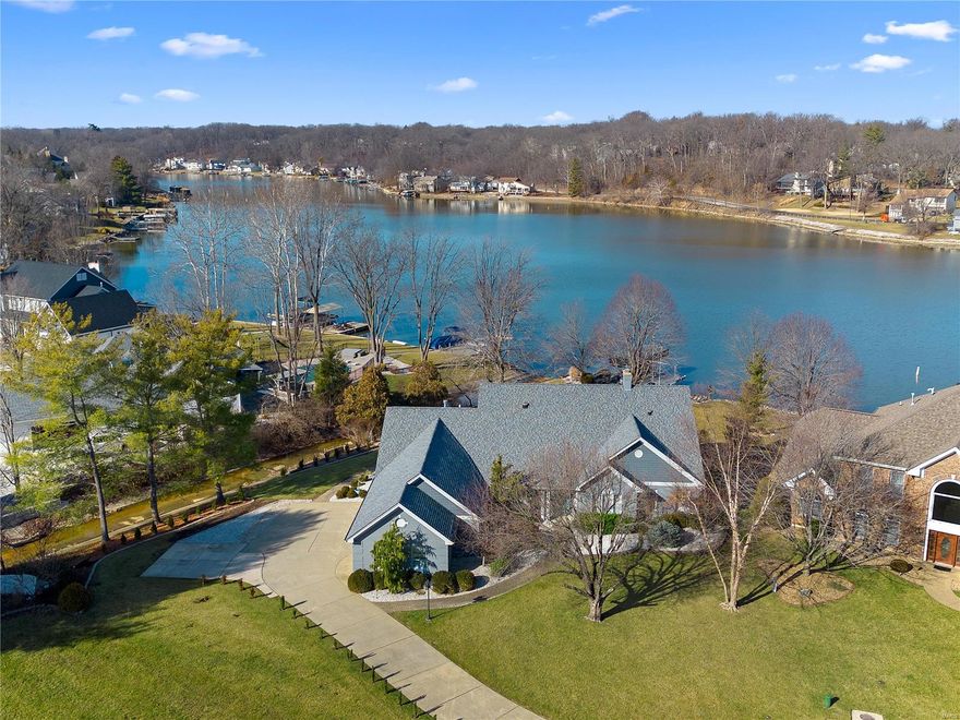 Magical waterfront with a level sidewalk 75’ from your patio to your dock!  Eagles, herons, egrets and more live in abundance in this calm, peaceful neighborhood. Everything you need is main level including the owner’s suite, laundry, 2 bedrooms and a study. Upstairs are 2 bedrooms and spacious family area open to an expansive maintenance free deck with incredible panoramic views.  You won’t believe the sunsets or the morning reflection of the sun rising over the lake! The level driveway accesses a 4-car side entry garage enhanced by lush landscape around the entire home.  Cozy interiors await with plantation shutters, electronic blinds, and charm to warm your heart. Extensive updates include: roof, siding, gutters, deck, dock, lift, kitchen, flooring, appliances, lighting, heated tile floors in sunroom, master bath and much more.  Move in and start enjoying a lifestyle of waterside relaxation and fun.  There’s room for a crowd and perfect ambiance for just you! Additional Rooms: Sun Room