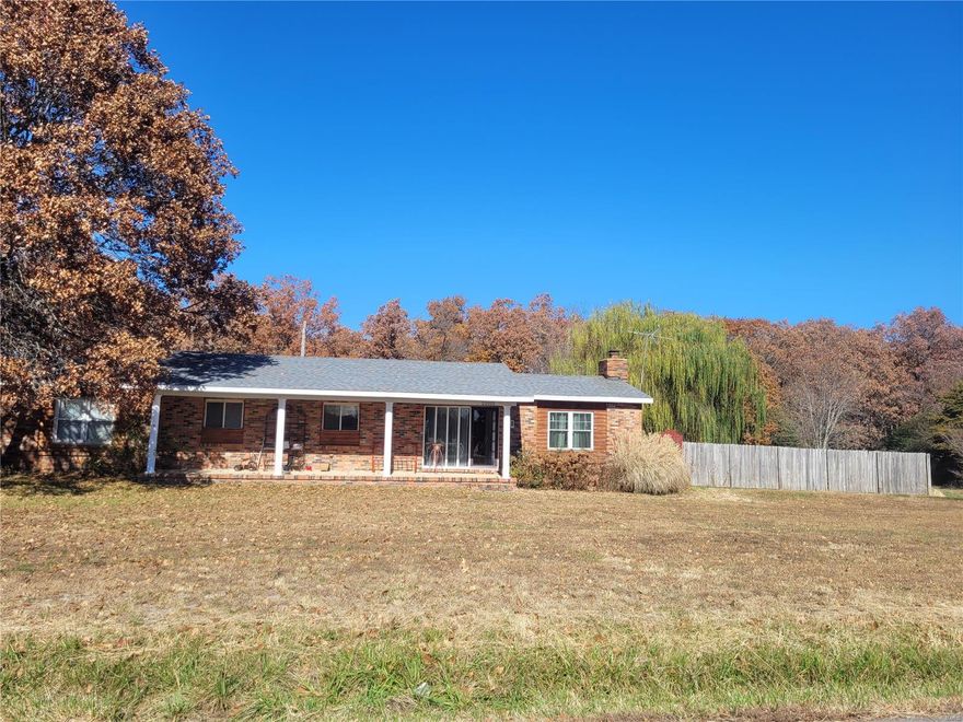This rustic brick and log 2 bed / 2 bath 1.668 sq ft home sits on 3 level acres +/-  just minutes outside of town. There is some unique ceiling structure in areas of the home. Cozy up by the beautiful brick fireplace w/insert during those cold winter nights. The kitchen is specious with plenty of nice cabinetry. The open dining / kitchen and sitting area are great for family gatherings. The open master bathroom completes the master bedroom. The laundry room is centrally located in the home for convenience. A large covered and enclosed back deck for semi outside activities and a large front porch supporting white roman style columns for those holidays decorations. The property has 2 water meters, so there's plenty of H2o for pets and watering vegetation. There is a 800 sq ft concrete floor shop with 220 electric. The massive Weeping Willow Tree really sets off this in the country home.