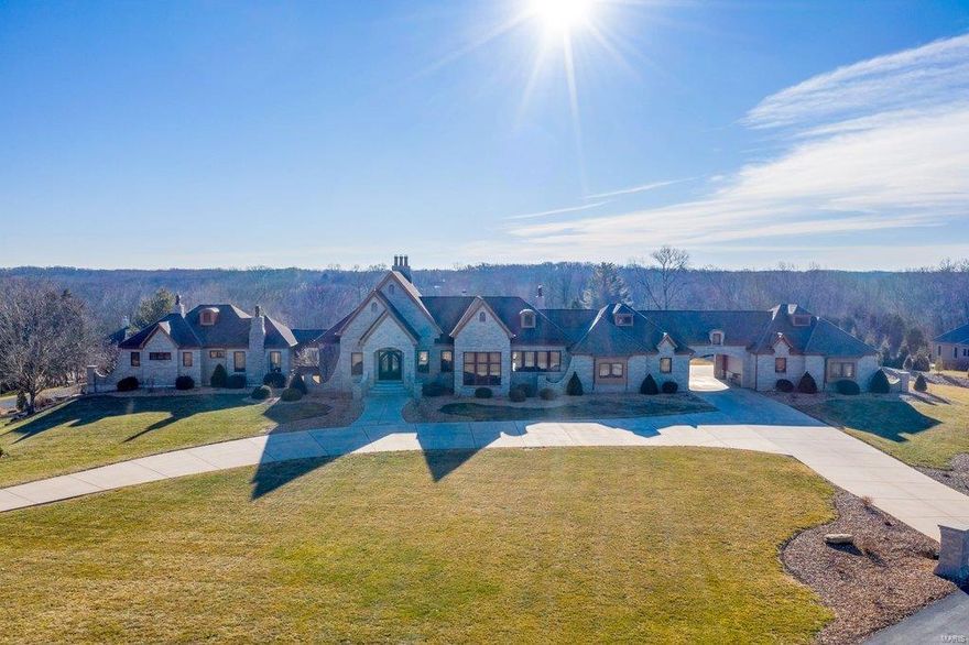 Handscraped hardwood & Travertine marble flooring, hand hewn beams & dramatic stone columns define the rustic elegance of this spectacular 11,500 sq ft Estate home. Expansive foyer leads to study with stone fireplace & spacious dining room that opens to deck. A cathedral ceiling with timber beam trusses & 26' fireplace set the tone for the stunning great room. Exceptionally large kitchen with knotty alder cabinetry, granite countertops & double islands adjoins vaulted hearth room highlighted by floor-to-ceiling fireplace & wine cellar. Sumptuous master bedroom suite combines the enjoyment of a stone fireplace with beautifully appointed bath with shower spa & jetted tub & private balcony. Walk-out Lower Level includes recreation room with 11' gathering bar, game room & media room plus office, hobby room, 5 additional bedrooms, 3 with ensuite baths & 2 with Jack n' Jill bath, & 2nd laundry. Situated on a 3-acre lot with deck, patio, 2 oversized 3-car garages, porte cochere & auto court. Additional Rooms: Wine Cellar