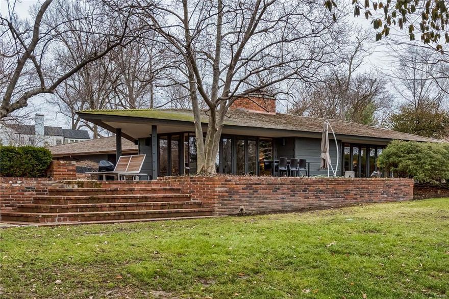 Designed by the esteemed firm of Bernoudy-Mutrux in 1952, the Simms house is a true masterpiece. The home features floor to ceiling windows that look onto the lush landscaping, patios & pool area. Vaulted ceilings with cove lighting are a hallmark of this home along with cypress wood paneling. The richly colored original concrete floors in the Living Room have been restored. The Living Room has a brick wood-burning fireplace, built-in sofas & formal dining area.  There is an adjoining Family Room with an informal dining area. The kitchen features new Subzero refrigerator, Dacor cooktop, Miele dishwasher, granite counters, skylight & a fireplace. The master bedroom suite is in its own wing with windows that look onto the pool area. The master bathroom has a large tub, separate shower, dual vanities & 2 large walk-in closets. The main floor has 2 more bedrooms & a full bath. The LL has a bedroom, bath, recreation room & walkout. The pool is saltwater, heated & has a covered cabana.