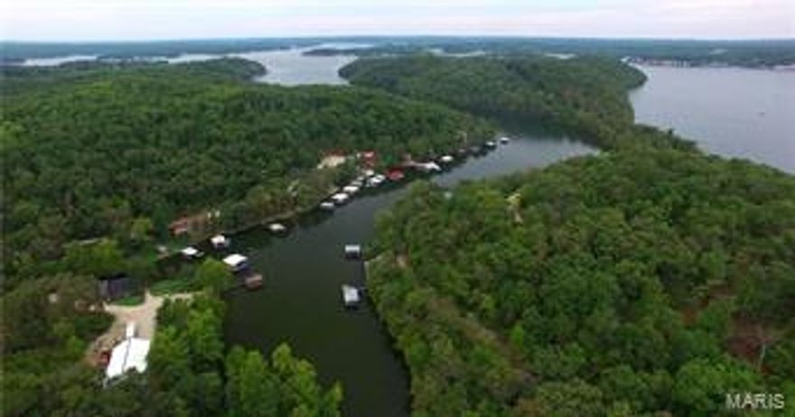 Approx. 670 wooded acres, already perimeter fenced with approx. 20 miles of perfectly manicured trails, offer abundant wildlife sign and countless ideal locations to harvest your next big buck or tom.  Several large areas have been cleared and are ready for your late season food plots.  3 springs which feed creeks throughout the property & several small ponds make perfect year round water sources for all the areas wildlife. With its lake access, breathtaking views and incredible sunsets, the most Southern portion of the property is a perfect location for your new secluded home or cabin.  Build how you like, when you like, or not at all. 2400 sq ft steel building with 600 sq. ft. of living quarters is located in the center of the property, perfect for storing all of your equipment and lake necessities.  Over 2 miles of blacktop frontage with county water & electric available. With its lake front access and proximity to all the attractions at Lake of the Ozarks.