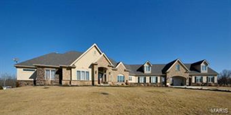 This impressive 6 bed/4.5 bath brick/stone front ranch rests upon equestrian friendly acreage that backs to open ground & woods. Long private drive leads to covered parking & two 3-car garages. Lovely landscaping w/ pond accent the front walk & soaring 12ft ceilings lend space throughout the wide open floorplan. Huge great rm w/ a toasty floor-to-ceiling stone fireplace. Atrium double doors open to the main floor den/4th bedrm. Breathtaking gourmet kitchen w/ huge center island, granite counters/breakfast bar, towering custom cabinetry, giant walk-in pantry & stainless appliances including professional gas range w/ hood, 2 dishwashers, wine cooler & trash compactor. Luxurious master suite w/ coffered ceiling, his & hers walk-in closets & a private full bath featuring double sinks, sunken tub & large walk-in shower. Partially finished walk-out lower level adds a big family rm, 2nd fireplace & stadium level theater room. 1600 sq ft carriage house w/ bath framed for finishing. Additional Rooms: Mud Room