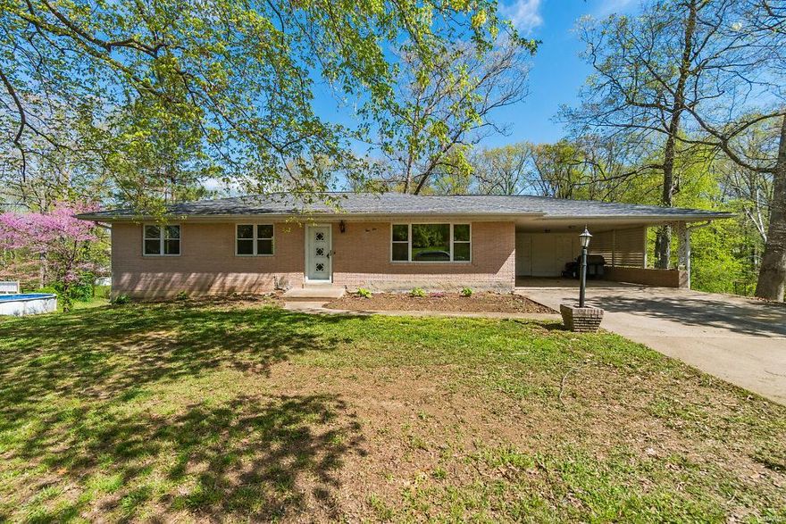 This Full Brick Three Bedroom, Two Bath home can be found in the Forest Acres Subdivision (off Indian Hills).  The living room, hallway, dining room, and all three main level bedrooms have original oak flooring.  The living room has big windows and curved crowned molding; check out the detailed plaster molding throughout.  Kitchen has ceramic tile flooring with plenty of white cabinets.  The master bedroom has a master bath with a walk-in tiled shower.  The full hall bathroom has ceramic tile flooring and a tub/shower combo.  The walkout full basement is unfinished with a storm shelter below the carport.  A door leads to the concrete patio.  The deep shaded lot (.68 acre) is backed by a small creek.  In 2014, the home received a new roof, new gutters, new windows (with marble sills), new HVAC.  Attached is an oversized two car carport.  Steps from the carport lead down to the patio.